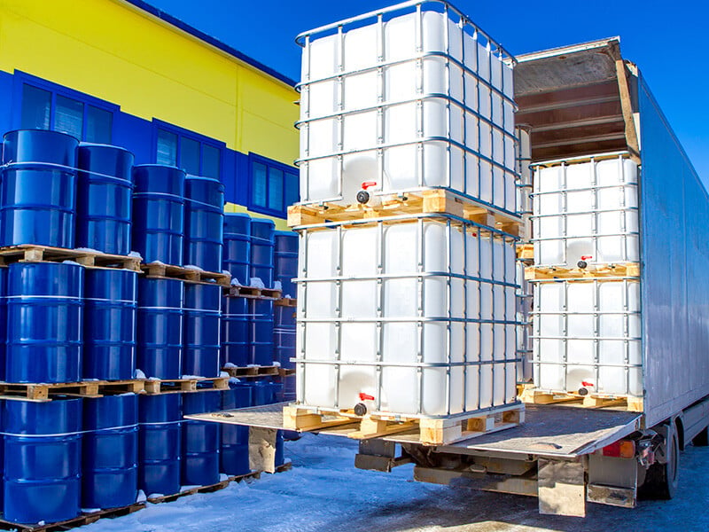 Blue and white barrels with chemicals on a truck