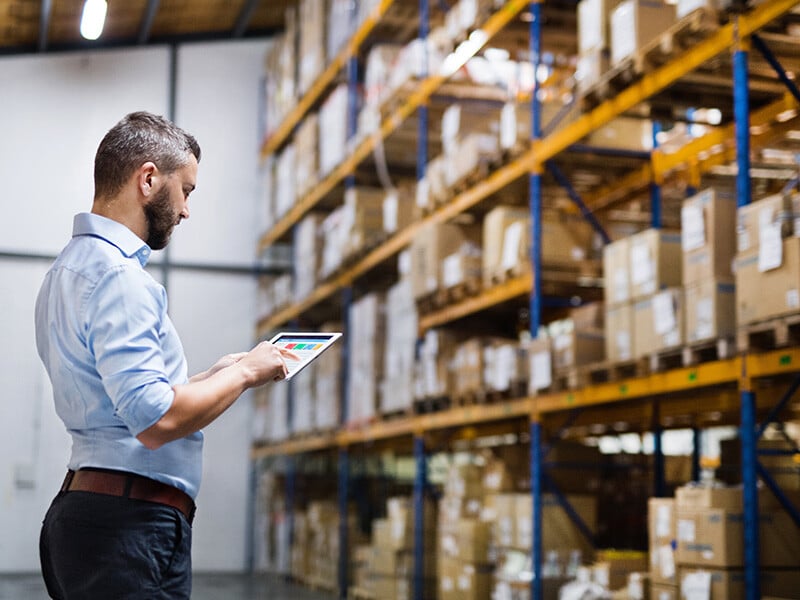 Man warehouse worker with a tablet