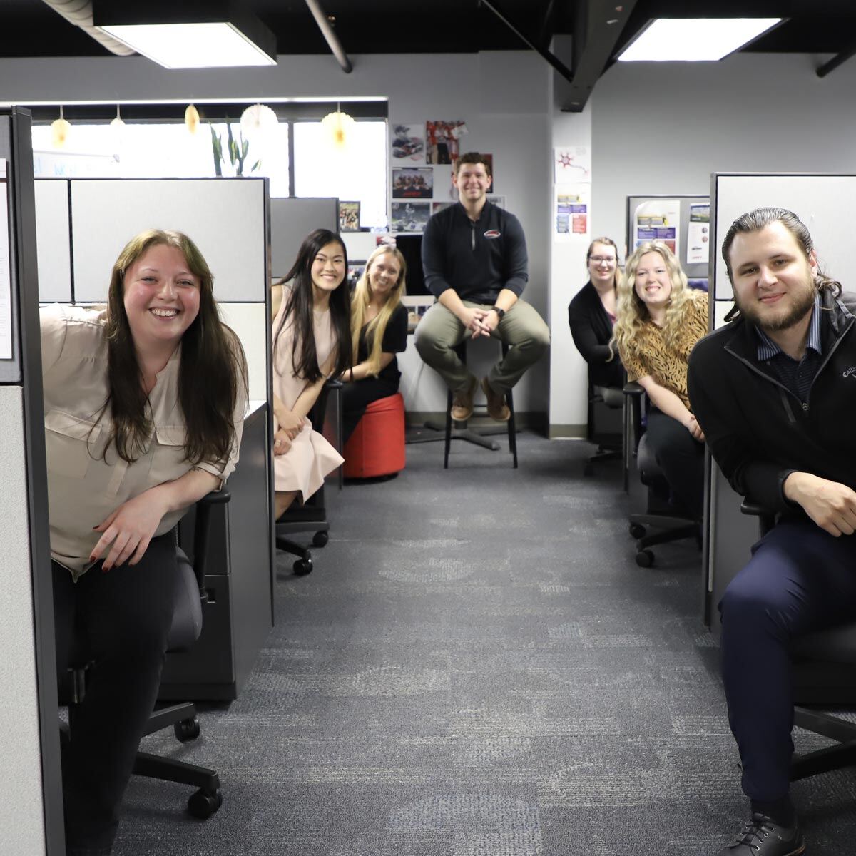 Smiling team members at their desks in Jarrett headquarters