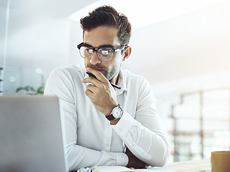 Business man working at a computer deep in thought