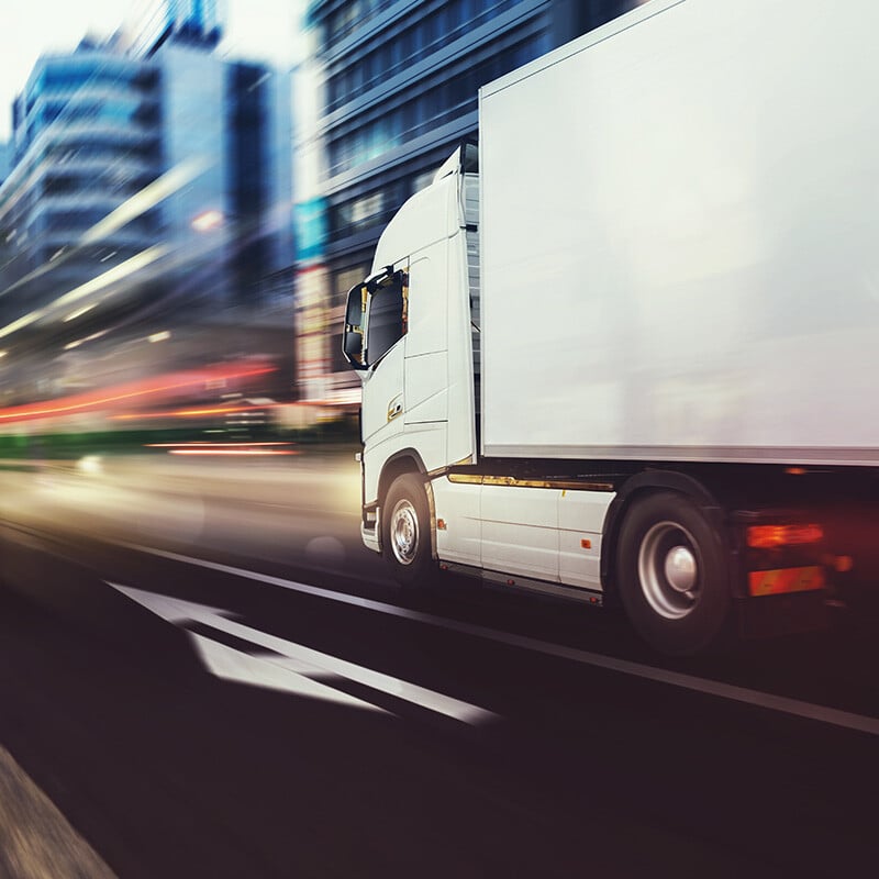 White truck moving fast on the road in a modern city with light effect