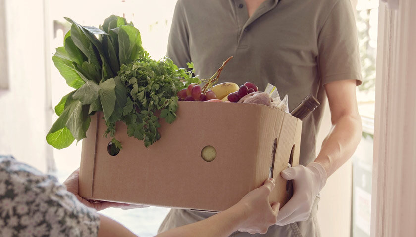 Woman giving a food donation box