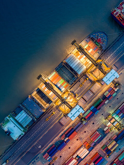 Overhead shot of a ship at dock with many shipping containers onboard